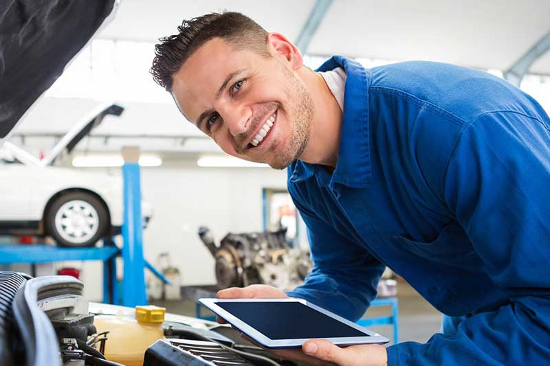 GMC service technician working on a vehicle at the dealership for about Hardy GMC.