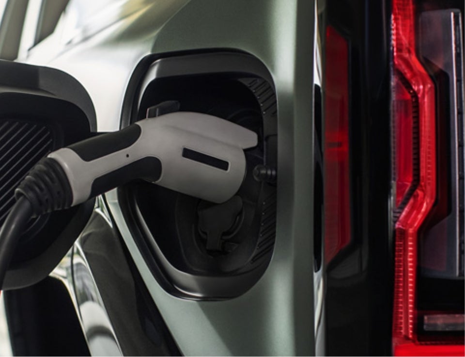 Close up of charging port with charger plugged in on a GMC Hummer EV SUV - Hardy GMC in Dallas GA
